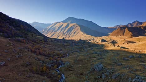 Drone-flight-above-autumn-fields-and-river-at-Caucasus-mountains-of-Georgia