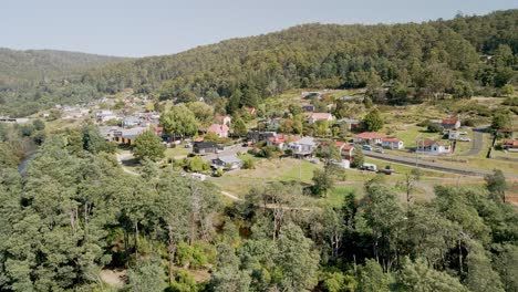 Tasmanian-tourism-town-of-Derby-aerial-shot-with-holiday-houses-and-forest-on-sunny-day,-Tasmania,-Australia