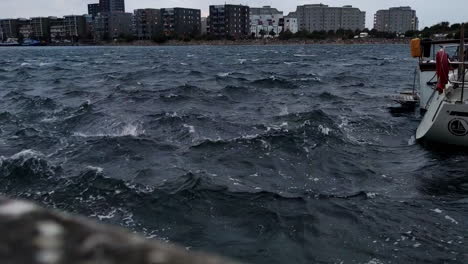 Agua-Ondulada-Del-Estrecho-De-Oresund-Con-La-Isla-De-Limhamn-Al-Fondo-De-Limhamns-Hamnomrade-En-Malmo,-Suecia