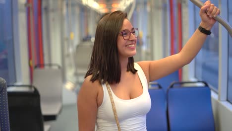 Mujer-Sonriendo-En-El-Autobús-Sosteniendo-La-Empuñadura-Por-Seguridad-Mientras-Viaja-En-Un-Medio-De-Transporte-De-Tren