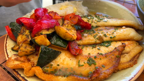 Sabroso-Pescado-Frito-Con-Verduras-Y-Arroz-Blanco-En-Un-Plato,-Comida-Tradicional-Española-En-España,-Toma-De-4k