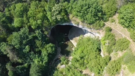 River-And-Gods-Bridge-Cave-Surrounded-By-Green-Forest-Near-Vratsa,-Bulgaria