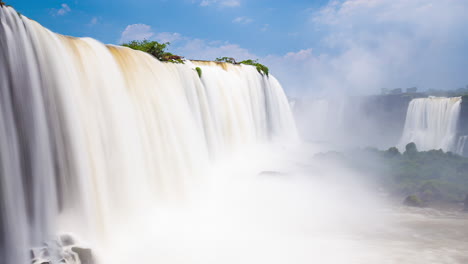 Timelapse-of-a-big-Waterfalls-of-Iguazu-around-a-big-green-area-and-a-river,-in-a-sunny-day,-Foz-do-Iguacu,-Parana,-Brazil