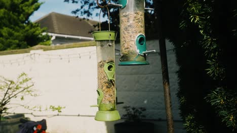 Slow-motion-shot-of-bird-feeders-swinging-in-the-wind