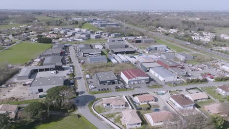 Commune-town-of-Montussan-France-in-the-southwest-country-with-homes-and-warehouses,-Aerial-dolly-out-shot