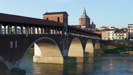 Nice-panorama-of-Pavia-,-Ponte-Coperto-is-a-bridge-over-the-Ticino-river-in-Pavia-at-sunny-day,-Pavia-Cathedral-background,-Italy