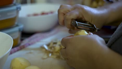 Person-Schält-Eine-Kartoffel,-Symbolisiert-Den-Prozess-Der-Lebensmittelzubereitung,-Gemüsevorbereitung-Zum-Kochen-Und-Die-Förderung-Einer-Vegetarischen-Ernährung-Und-Gesunder-Essgewohnheiten