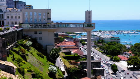 Aerial-view-of-Elevador-Lacerda,-the-neighborhood-around-and-the-sea-at-background,-Salvador,-Bahia,-Brazil