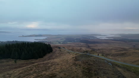 Lateral-Linear-Aerial-of-Road-on-Hill-With-Lochs-in-Scotland