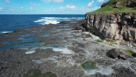 Volando-Alrededor-De-La-Reserva-Acuática-De-La-Isla-Cook-Con-Olas-Rompiendo-En-Fingal-Head,-Nueva-Gales-Del-Sur,-Australia