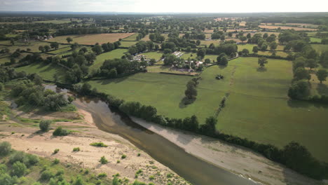 Vista-Aérea-Lateral-De-Arco-Amplio-Del-Río-Que-Fluye-A-Través-De-Un-Exuberante-Paisaje-Verde