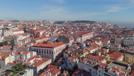 Aerial-slow-pan-across-city-and-tall-multi-story-buildings-along-Lisbon-Portugal-dense-cityscape