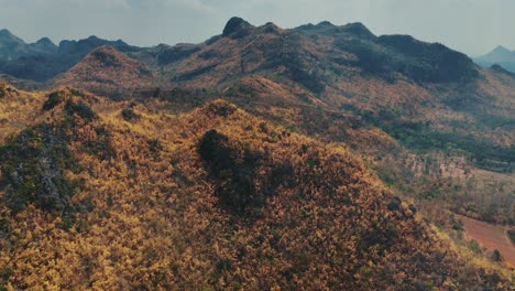 A-mesmerizing-drone-shot-captures-the-slow-unveiling-of-a-mountain-range-in-Sangklaburi,-Thailand