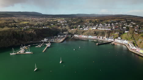 Lateral-Linear-Aerial-of-Majestic-Port-of-Tobermory-Surrounded-by-Hills-and-Trees