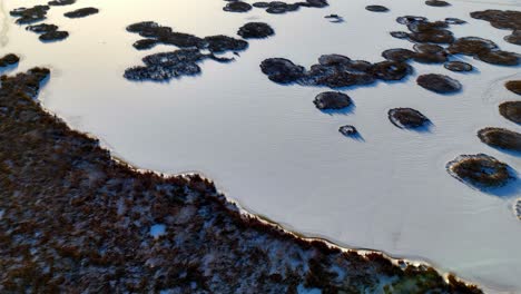 aerial-view-of-a-frozen-lake-with-several-islands-jutting-out-of-the-ice