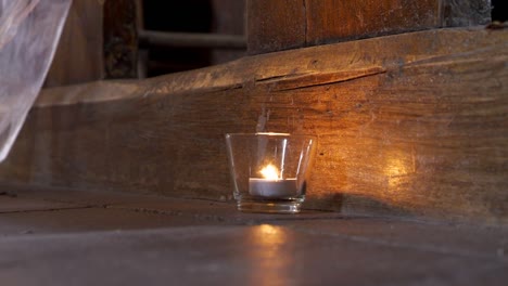 Candlestick-with-a-lit-candle-serving-as-a-decoration-in-an-old-church