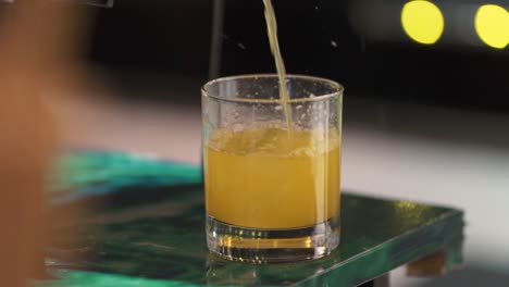 Orange-drink-poured-into-a-glass-at-wedding-party-bar