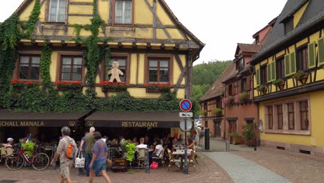 People-Pass-Half-Timbered-House-with-gingerbread-Placed-on-Windows-in-a-Kayserberg-Village