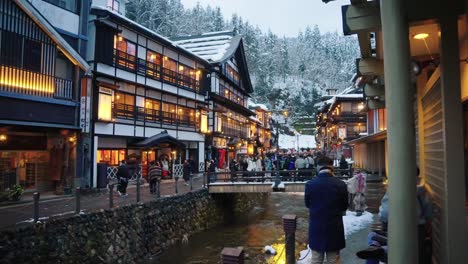 Panorámica-En-Cámara-Lenta-Que-Establece-Una-Toma-De-La-Tradicional-Ciudad-Onsen-Con-Techos-Nevados