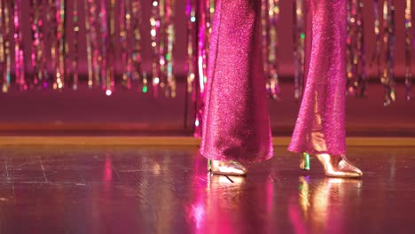 Vintage-fashion-Close-up-of-1970´s-sparkling-pink-ladies-bell-bottom-pants-and-shine-gold-high-heels-shoes-disco-dancing