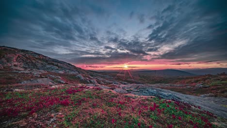 The-red-setting-sun-moves-slowly-on-the-horizon-and-above-the-autumn-tundra,-lighting-the-clouds-with-a-reddish-glow