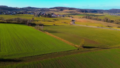 Dramatic-Aerial-Shot-of-Winding-Road-Cutting-Through-Lush-Farmlands