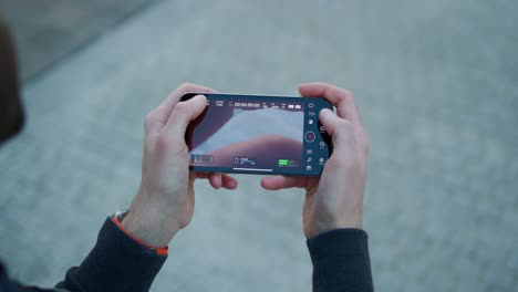 Smartphone-held-in-hands-close-up,-adjusting-menu-settings-and-camera-features-for-taking-video