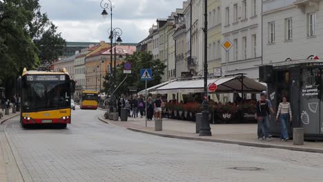 Ein-Bunter-Rot-gelber-Bus-Fährt-Durch-Eine-Warschauer-Straße-Mit-Touristen-Und-Einwohnern