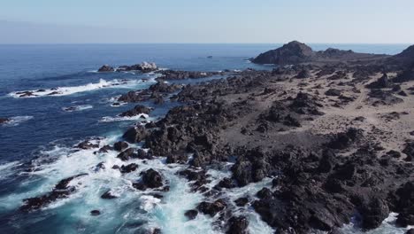 Low-aerial-flyover:-Jagged-shore-rocks-on-arid-Pacific-coast-of-Chile