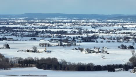 Aerial-landscape-shot-of-a-rural-farm-field-covered-in-snow