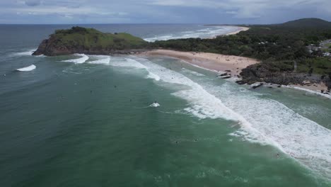 Surfers-At-Riding-Rough-Sea-Waves-In-Cabarita-Beach-Adjacent-To-Norries-Headland-In-NSW,-Australia