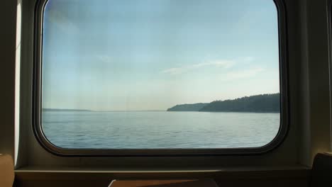 View-out-of-a-commuter's-ferry-in-the-PNW-with-an-empty-booth
