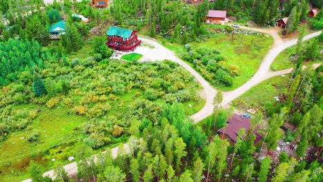 Cabins-in-the-Woods-Surrounded-by-Pine-Tree-Forest-in-an-Isolated-Rural-Neighborhood-with-Dirt-Roads