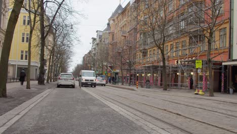 City-traffic-drives-along-tram-line-on-cobbled-city-street-Bulevardi-in-Helsinki
