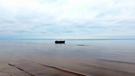Small-wooden-fishing-boat-floating-on-a-still-body-of-water-on-a-cloudy-day
