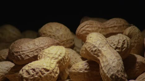 Imágenes-De-Maní-Girando-Sobre-Un-Fondo-Oscuro,-Que-Muestran-Una-Vista-De-Primer-Plano-De-Las-Nueces.