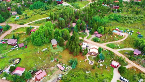Aerial-Drone-Fly-Over-of-Cabins-in-the-Woods-Surrounded-by-Pine-Tree-Forest