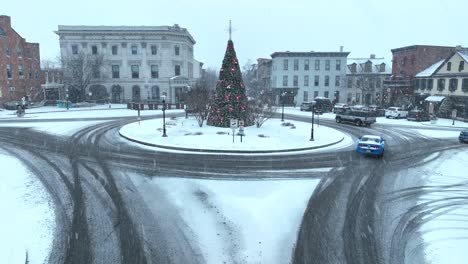 Verschneiter-Kreisverkehr-Mit-Geschmücktem-Weihnachtsbaum-Und-Historischen-Gebäuden