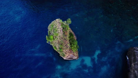Rock-Formation-With-Vegetation-In-The-Ocean-In-Nusa-Penida,-Bali,-Indonesia