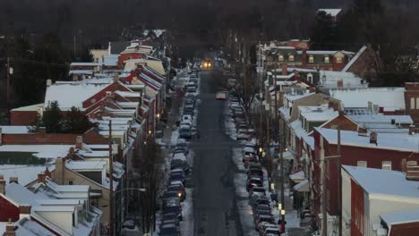 Straight-street-with-parking-cars-in-american-suburb-neighborhood-in-winter-snow