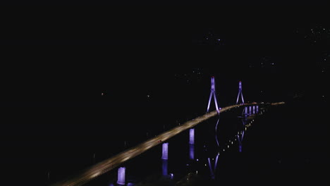 Cable-stayed-bridge-lit-up-at-night,-aerial-view