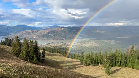 Rainbow-start-place-revealed-with-a-slow-panning-from-right-to-left-near-Durau-mountains-in-Romania