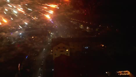 The-drone-captures-a-dazzling-display-of-fireworks-illuminating-the-night-sky-during-the-end-of-year-celebrations,-creating-a-spectacular-and-festive-atmosphere