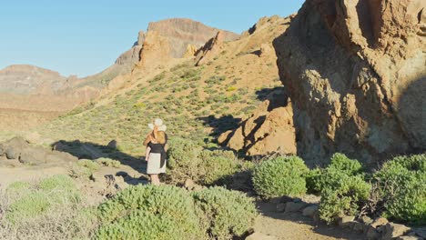 Young-mother-with-child-on-her-hands-walking-in-hilly-landscape-of-Tenerife