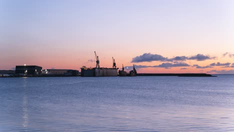 Timelapse-of-Reykjavik-harbor,-vivid-sunset-with-rolling-clouds-soaring-over-Pacific
