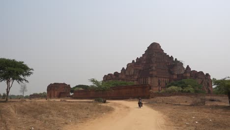 Una-Scooter-Pasa-Frente-A-Un-Templo-En-Beginn,-Myanmar.