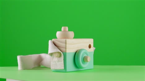 Minze-Holz-Fotokamera-Spielzeug-Auf-Grünem-Hintergrund-Chroma-Key-Hintergrund-Ersatz-Hintergrund-Objekt-In-Einem-Plattenspieler-3D-Spinnschleife