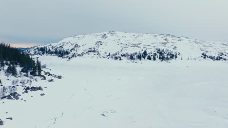 Volando-Sobre-Un-Lago-Congelado-Cubierto-De-Nieve-En-Invierno-En-Verran,-Indre-Fosen,-Noruega