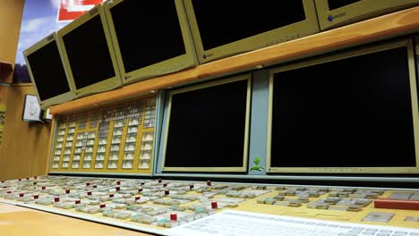 Close-up-of-multiple-monitors-and-large-keyboard-panel-at-control-room