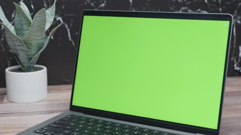 Closeup-of-green-screen-laptop-for-website-mockup-on-black-marble-background